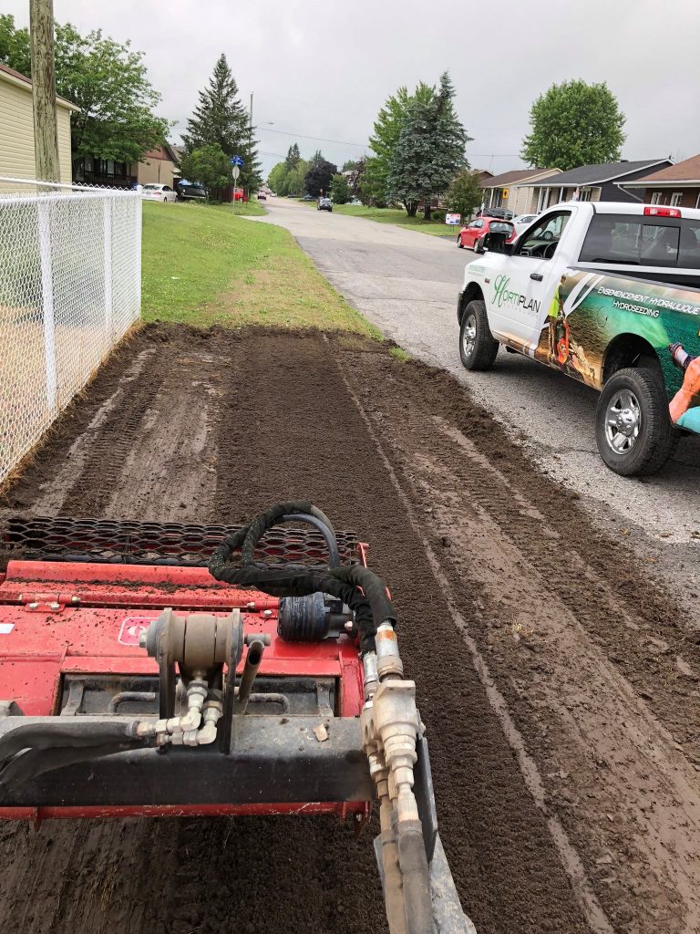 Tracteur en action, raclant et étendant la terre topsoil, pour un ensemencement réussi ou à la pose de tourbe