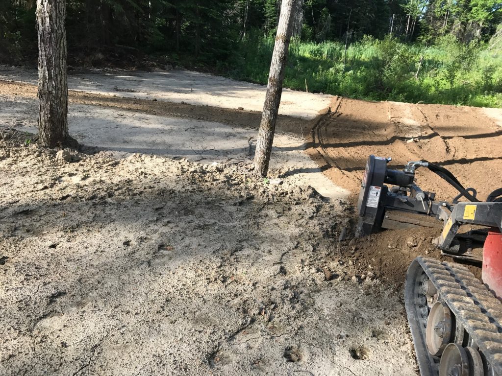 Tracteur en action préparant le terrain topsoil pour la pose de tourbe, étape essentielle dans l'aménagement paysager