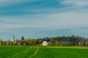 Aylmer Québec paysage champêtre avec église historique et manoir entourés de verdure sous un ciel bleu printanier